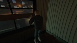A player in a dark jacket presses a board against a window, in a room with striped wallpaper.