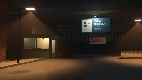 The guard booth at Gate 04 under a lamp, with the Crew Admission sign and a District Closed notice on the fence.